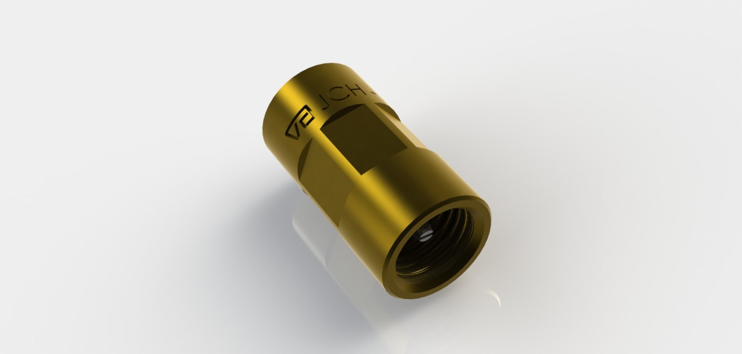 Gold-colored cylindrical metal connector with internal threads, angled on a white reflective surface.