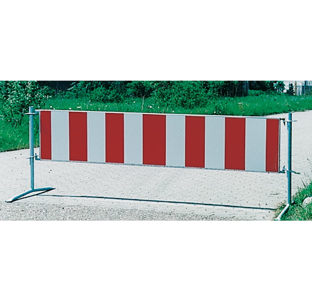 Barrier gate with red and white vertical stripes blocking a gravel path
