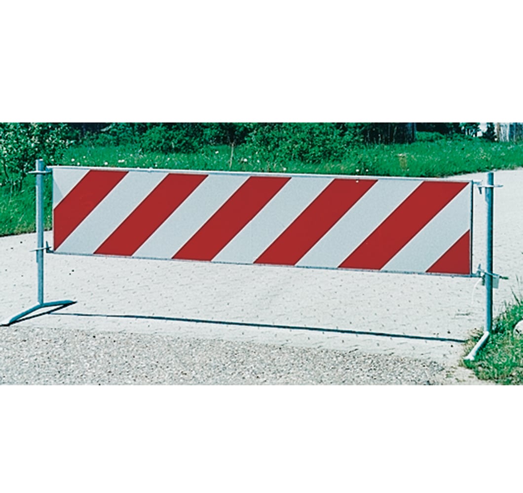 Barrier with red and white diagonal stripes blocking a roadway, indicating construction or closure on the path
