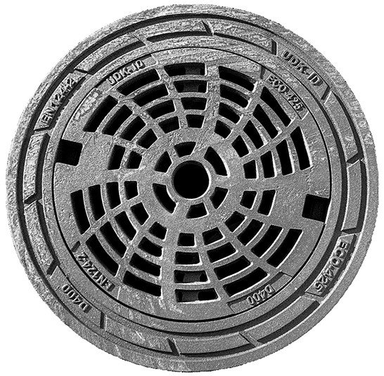 Round metal manhole cover with a circular grid pattern and central opening, appears weathered and iron-gray.