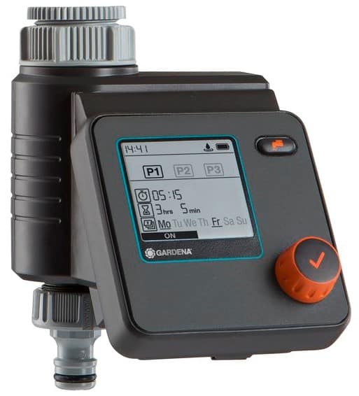 Gardena irrigation timer/controller with digital display, orange rotary dial, and connection port; shows schedule icons and controls for watering settings.