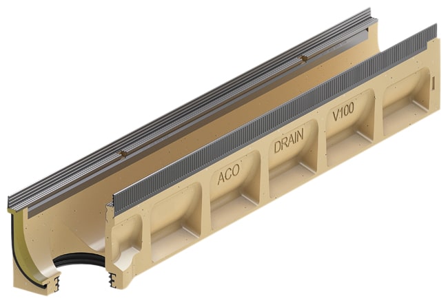 Beige plastic linear trench drain channel with a metal grate on top, featuring multiple compartments labeled ACO DRAIN V100 and a curved outlet end visible on the side.