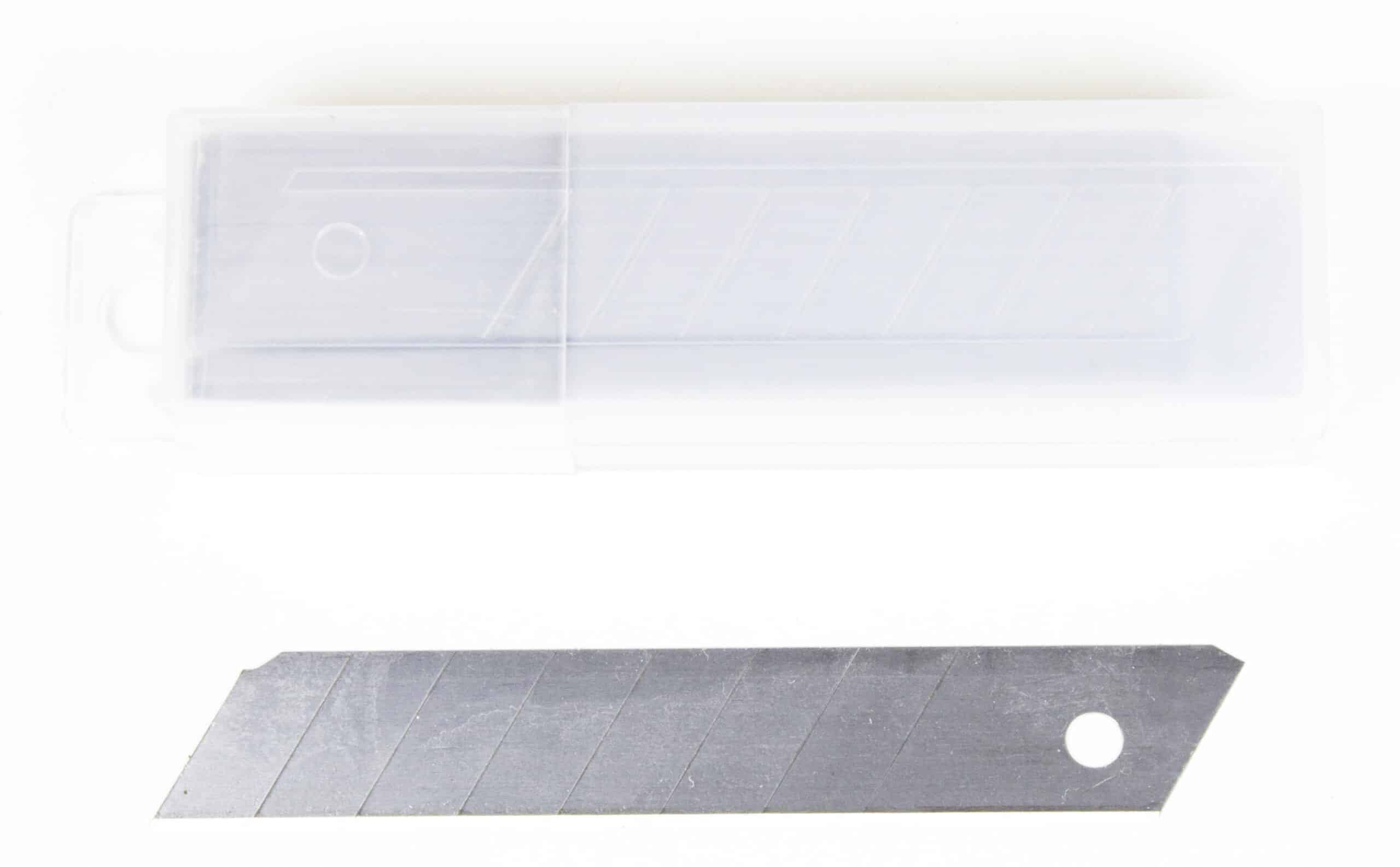 Clear plastic case aligned horizontally above a dark metal ruler with diagonal grooves and a circular hole, both on a white background.