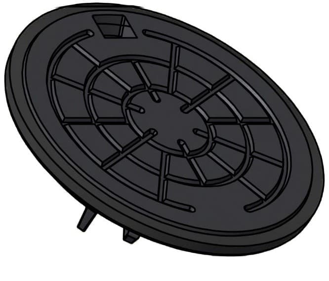 Dark round manhole cover viewed from an oblique angle, showing its circular pattern and inner spokes with a small access slot at the edge
