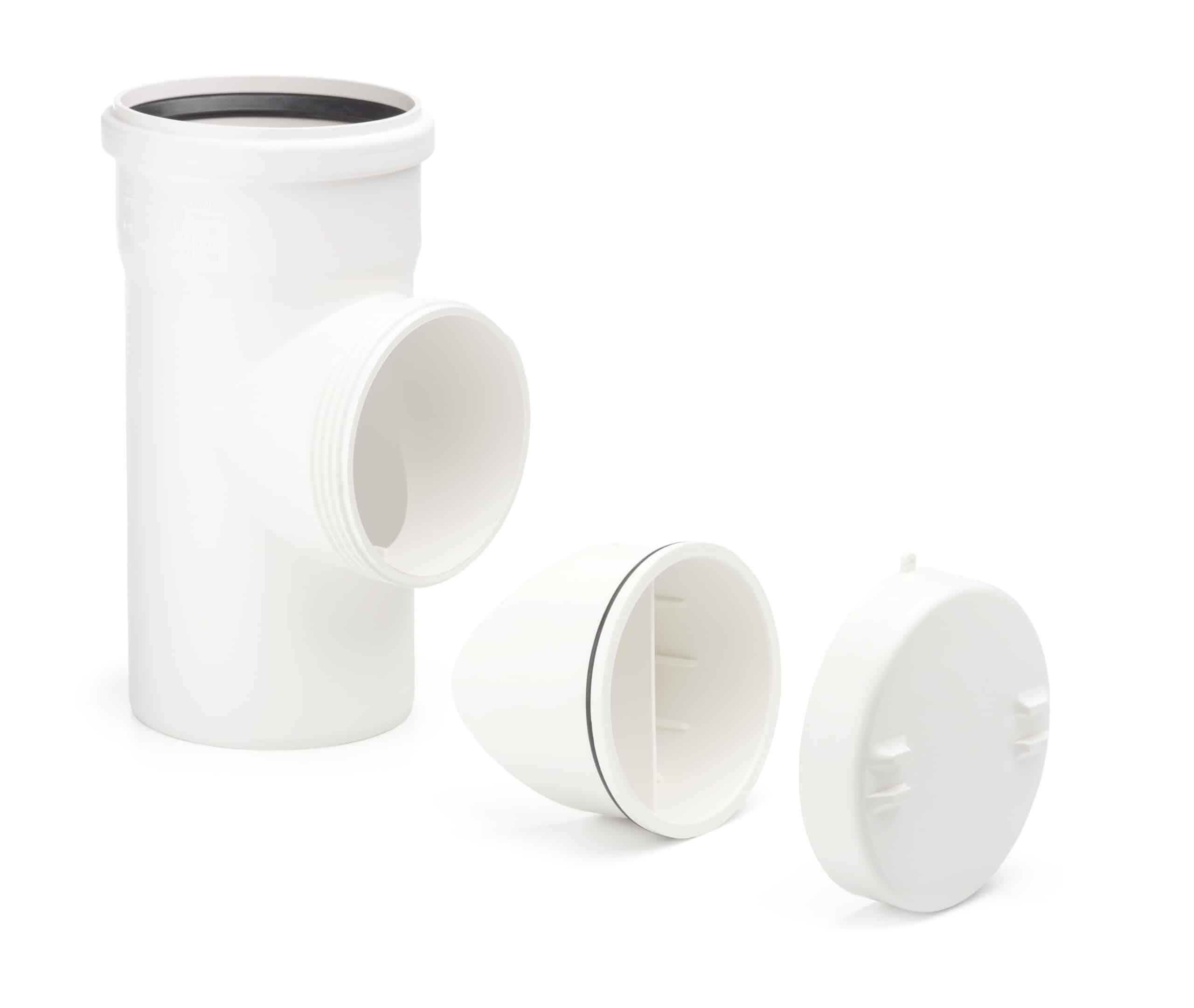 White PVC plumbing fittings arranged on a white background, including a vertical pipe with a slip end and two circular caps