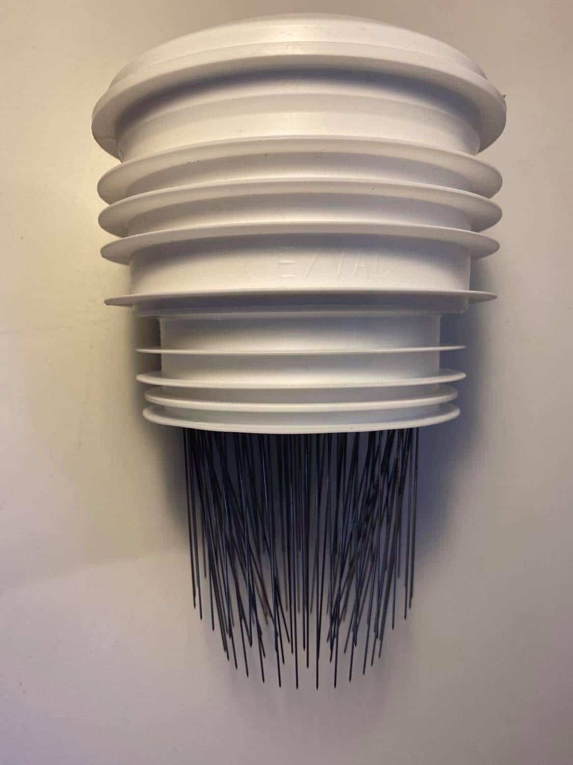 White plastic bottle brush head with stacked ridges and long black bristles at bottom (side view).