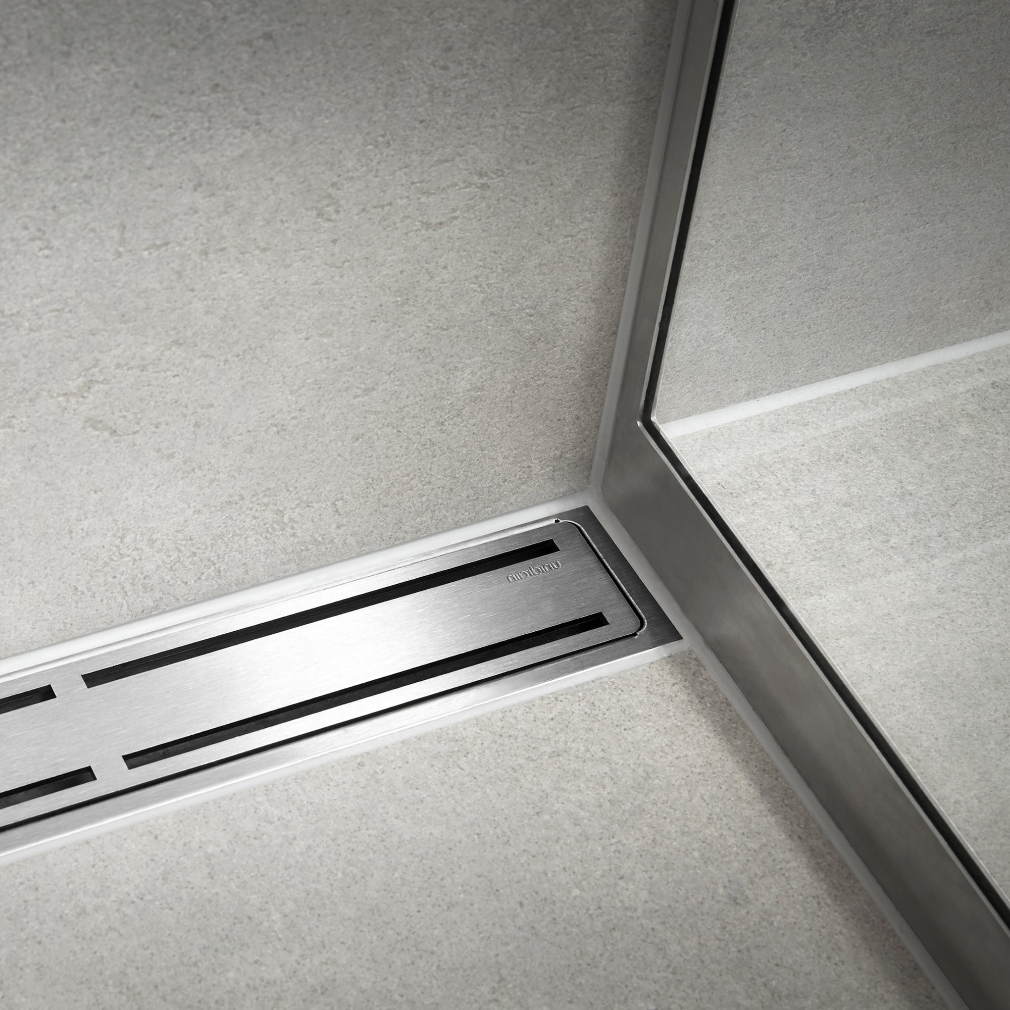 Close-up of a stainless steel escalator step with black tread slots and surrounding metal paneling seen at an angle.