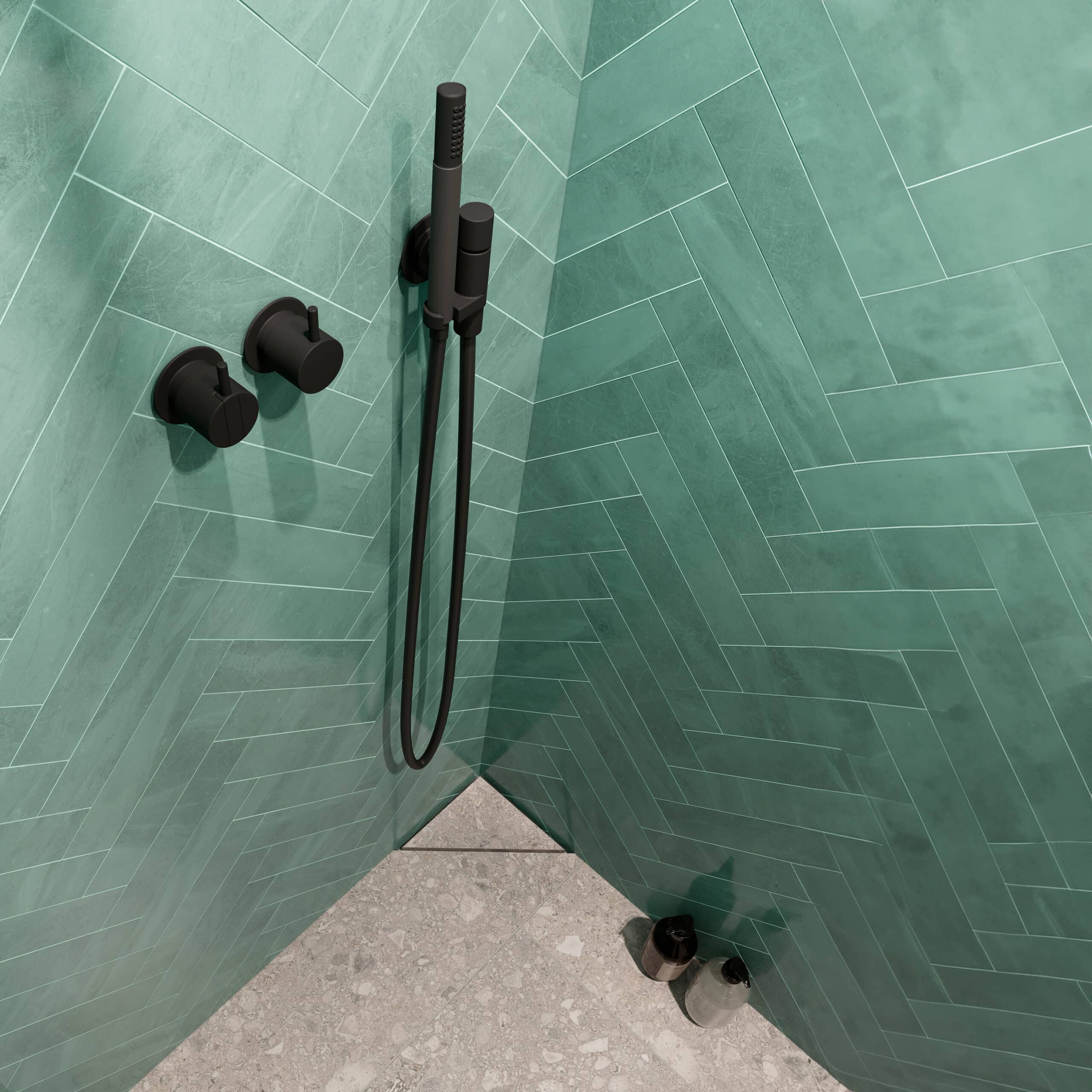 Green tiled shower with a handheld showerhead and wall-mounted control knobs in a corner.
