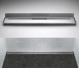 Metal wall-mounted paper towel dispenser above a vented baseboard and dark carpeted floor.